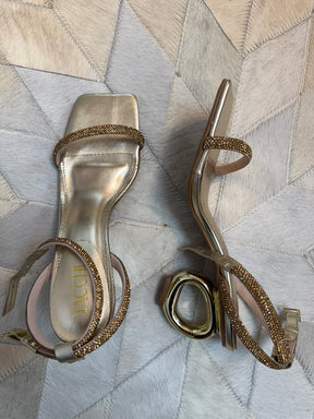 Sandália dourada com salto escultural e tiras de strass – luxo e modernidade no mesmo modelo